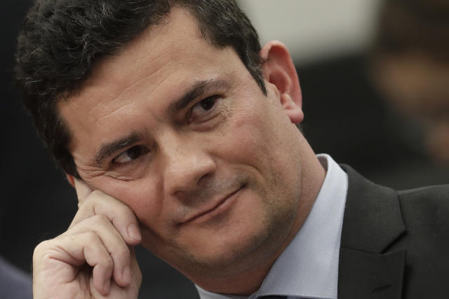 Brazil's Justice Minister Sergio Moro smiles during his testimony before a House Commission, in Brasilia, Brazil, Tuesday, July 2, 2019. Press reports have accused him of allegedly coordinating with prosecutors, improperly advising them in a case against former President Luiz Inácio Lula da Silva. Moro and prosecutors deny any wrongdoing, but the Brazilian Bar Association has called for the suspension of the minister and others pending an inquiry. (AP Photo/Eraldo Peres)