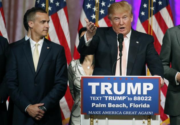 Campaign manager Corey Lewandowski (L) stands next to Republican U.S. presidential candidate Donald Trump during a news conference in Palm Beach, Florida, in this file photo taken March 15, 2016. Lewandowski was arrested in Florida on Tuesday and charged with simple battery for intentionally grabbing and bruising the arm of Michelle Fields, police records show. (REUTERS/Joe Skipper)