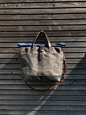 Waxed canvas roll top tote bag with luggage handle attachment