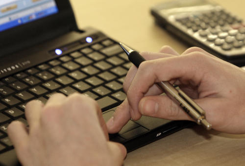 FILE - In this Feb. 1, 2012 file photo, a student works with a computer and a calculator at Reynoldsburg High School in Reynoldsburg, Ohio. According to a new survey from Pew Research Center released Monday, March 16, 2015, more than half of Americans are worried about the U.S. government’s digital spies prying into their emails, texts, search requests and other online information, but few are trying to thwart the surveillance. (AP Photo/Jay LaPrete, File)