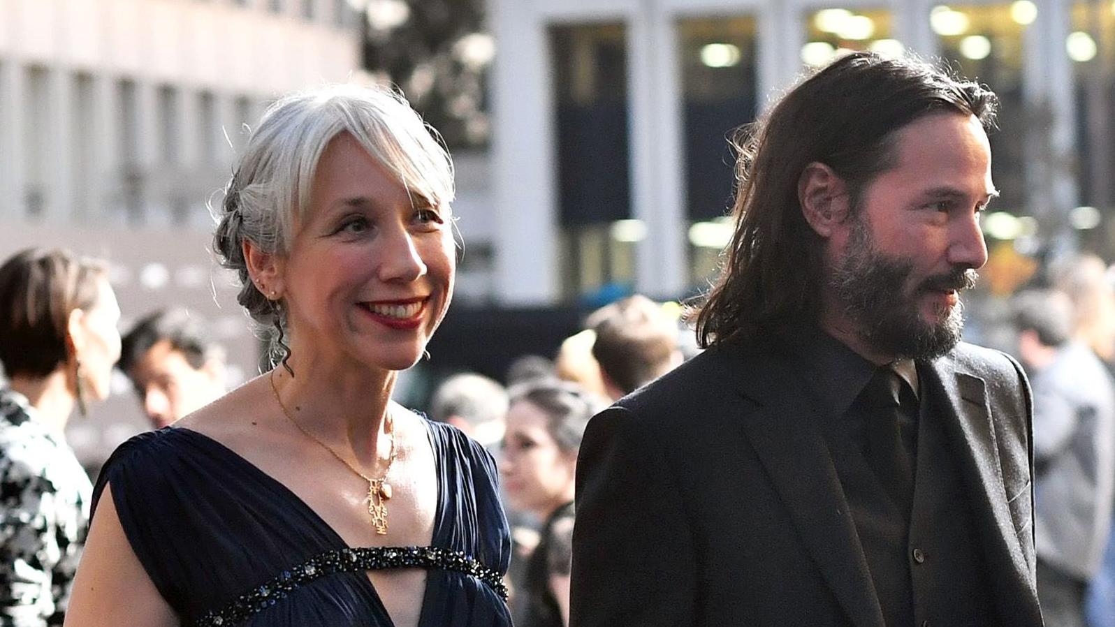 Who is the woman holding hands with Keanu Reeves?