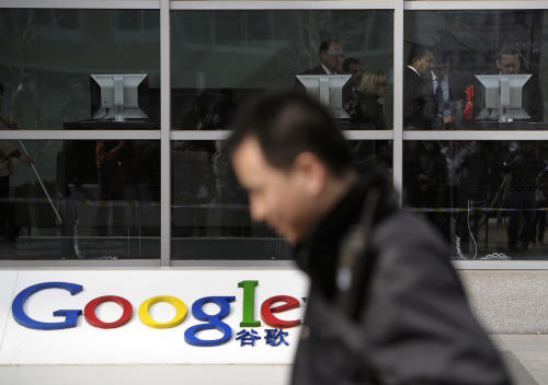 FILE - In this March 23, 2010 file photo, a security guard walks past while foreign visitors are seen inside the Google China headquarters in Beijing. Connections to Google Inc.'s popular email service have been blocked in China amid efforts by the government to limit access to the company's services. Records from Google's Transparency Report show online traffic from China to Gmail dropped to zero on Saturday, Dec. 27 although there was a small pickup on Monday, Dec. 29, 2014. (AP Photo/Andy Wong, File)