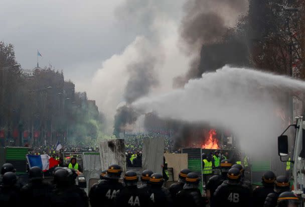 PHOTO: Protesters wearing yellow vests, a symbol of a French drivers' protest against higher fuel prices, run from police during riots on the Champs-Elysees in Paris, Nov. 24, 2018. (Gonzalo Fuentes/Reuters)