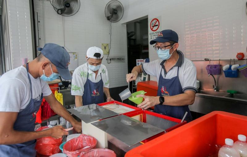 Funny Mountain Soya Beancurd shop supervisor Tan Han Seng (right) serves drinks to a customer in Ipoh November 12, 2020.