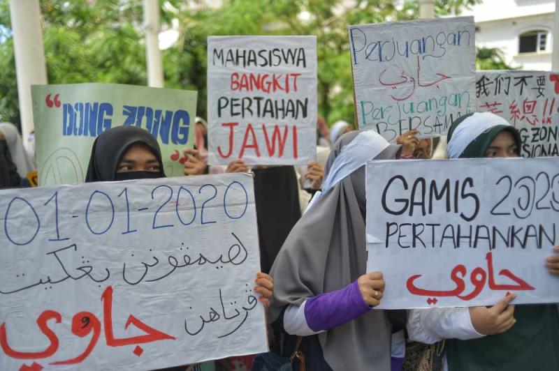 Protesters hold placards as they staged a peaceful protest in Kuala Lumpur January 1, 2020.