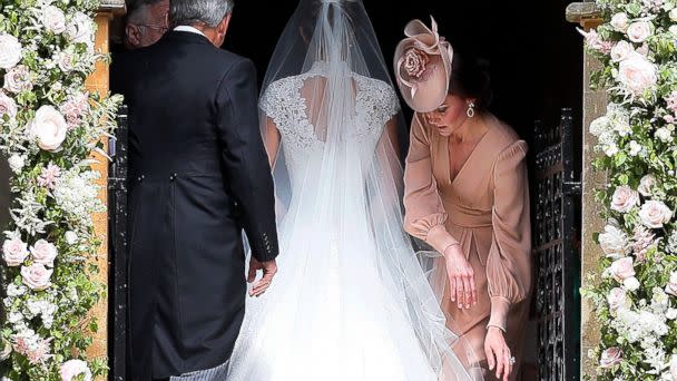 PHOTO: Kate, Duchess of Cambridge, arranges the train of her sister Pippa Middleton as she arrives with her father Michael Middleton for her wedding to James Matthews at St Mark's Church in Englefield, England, May 20, 2017. (Kirsty Wigglesworth/AP)