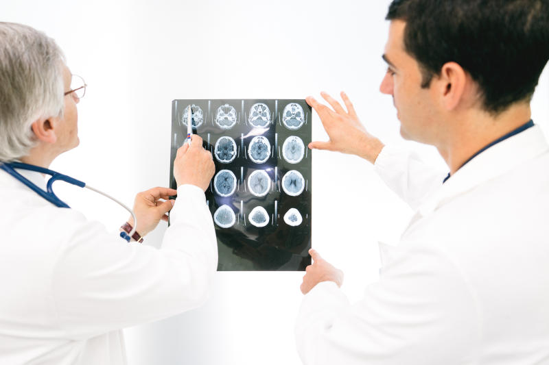 Two doctors examine a brain scan