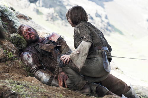 In this image released by HBO, an injured Sandor Clegane, better known as The Hound, portrayed by Rory McCann, left, and Arya Stark, portrayed by Maisie Williams, appear in a scene from season four of "Game of Thrones." The season five premiere airs on Sunday. (AP Photo/HBO, Helen Sloan)