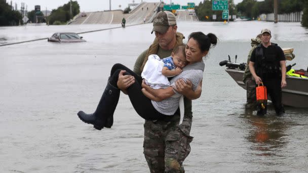 PHOTO: Houston Police SWAT officer Daryl Hudeck carries Catherine Pham and her 13-month-old son Aiden after rescuing them from their home surrounded by floodwaters from Tropical Storm Harvey, Aug. 27, 2017, in Houston. (David J. Phillip/AP)