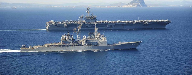 The Ticonderoga-class guided missile cruiser USS Vicksburg escorts the Nimitz-class aircraft carrier USS Theodore Roosevelt (top) as they pass the Rock of Gibraltar in the Mediterranean Sea. (U.S. Navy/Reuters)