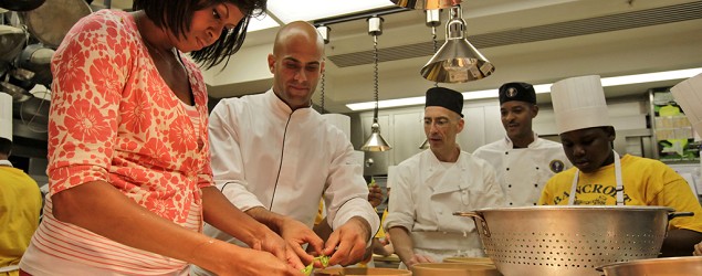 Michelle Obama, left, and chef Sam Kass, second from left, shell peas with fifth graders from Bancroft Elementary School in the kitchen of the White House. (Alex Brando/AP)