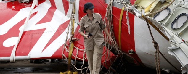 An Airbus investigator near part of the tail of the AirAsia QZ8501 passenger plane. (Darren Whiteside/Reuters)