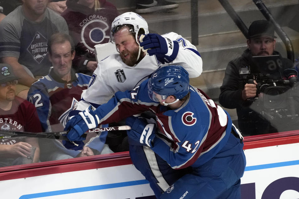 Tampa Bay Lightning left wing Alex Killorn, top, is pressed against the boards by Colorado Avalanche defenseman Josh Manson (42) during the second period of Game 1 of the NHL hockey Stanley Cup Final on Wednesday, June 15, 2022, in Denver. (AP Photo/David Zalubowski)