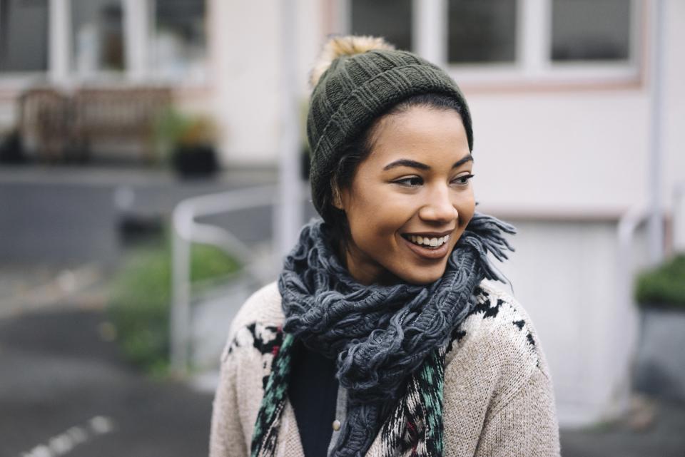 <h1 class="title">Smiling young woman wearing wooly hat outdoors</h1><cite class="credit">Getty Images</cite>