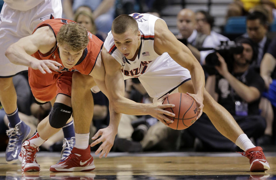 Utah's Dallin Bachynski, left, and Arizona's Kaleb Tarczewski scramble for a loose ball during the first half of an NCAA college basketball game in the quarterfinals of the Pac-12 Conference tournament, Thursday, March 13, 2014, in Las Vegas. (AP Photo/Julie Jacobson)