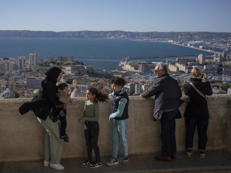 People visit the Notre Dame de la Garde Basilica in Marseille, southern France, Friday, April 19, 2024. (AP Photo/Daniel Cole)