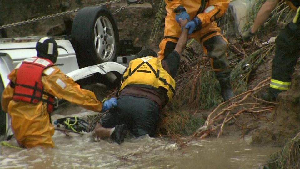 Emergency personnel work to rescue a man trapped in his vehicle during flooding of Rock Creek in Lafayette, Colorado September 12, 2013, in this photo courtesy of CBS4 Denver. The National Weather Service has issued a flash flood warning for central Boulder County that will remain in effect through at least 10 a.m. local time. (REUTERS/CBS4 Denver/Handout via Reuters)