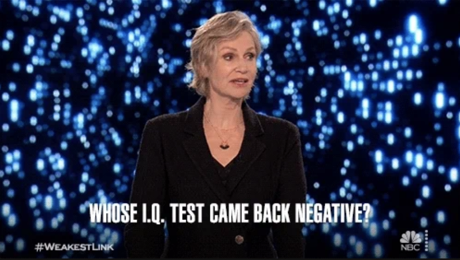 Jane Lynch in a black suit on 'Weakest Link' game show with text overlay: "Whose I.Q. test came back negative?" and hashtags #WEAKESTLINK, #NBC