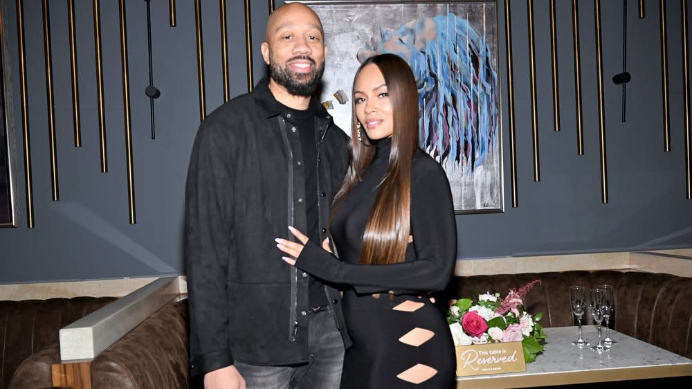  LaVon Lewis and Evelyn Lozada from Queens Court hugging at a restaurant . 