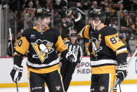 Pittsburgh Penguins' Lars Eller (20) celebrates with Sidney Crosby (87) after scoring during the second period of an NHL hockey game against the Detroit Red Wings in Pittsburgh, Sunday, March 17, 2024. (AP Photo/Gene J. Puskar)