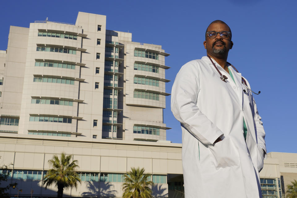 Dr. David Tom Cooke, head of general thoracic surgery at UC Davis Health, poses outside the UC Davis Medical center in Sacramento, Calif., Friday, Dec. 18, 2020. Cooke participated in Pfizer's clinical trial for the coronavirus as part of an effort to reduce skepticism about the vaccine among African Americans. He's now promoting the vaccine's safety and the importance of taking it on his social media pages. (AP Photo/Rich Pedroncelli)