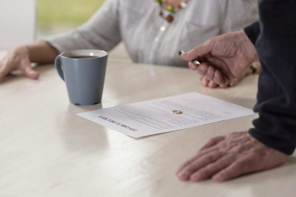 senior Husband waiting for his wife to sign the divorce decree