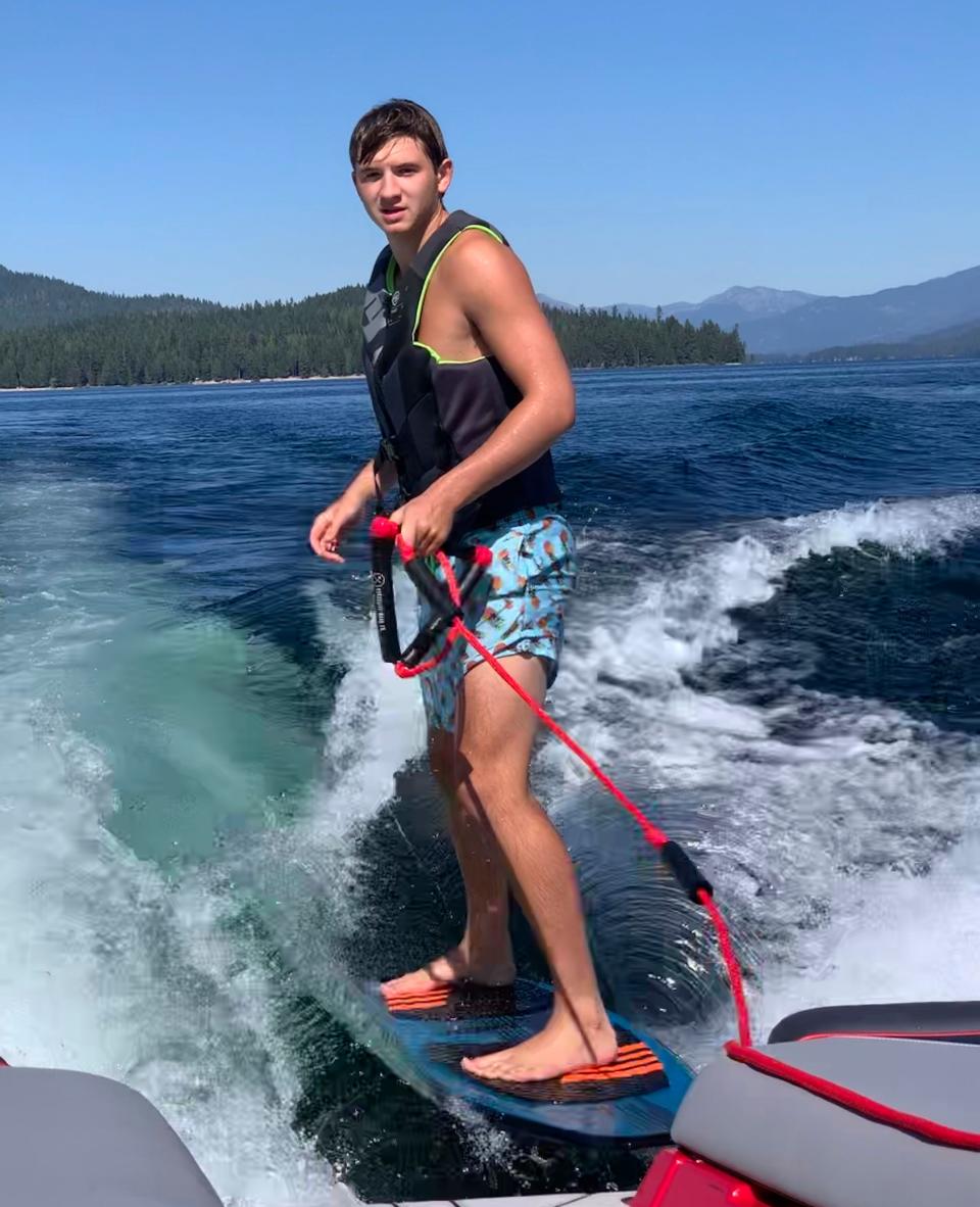 In this photo provided by Stacy Chapin, Ethan Chapin surfs on Priest Lake in northern Idaho in this family snapshot from July 2022. Chapin was one of four University of Idaho students found stabbed to death in a home near the Moscow, Idaho campus on Sunday, Nov. 13, 2022. Police are still searching for a suspect in the case.