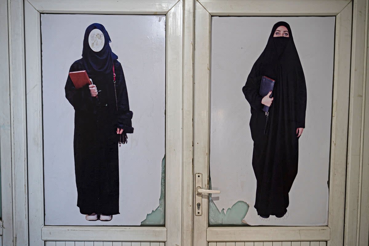 A poster pasted on a door ordering women to cover themselves with a hijab is pictured at a private university in Kabul (AFP via Getty)