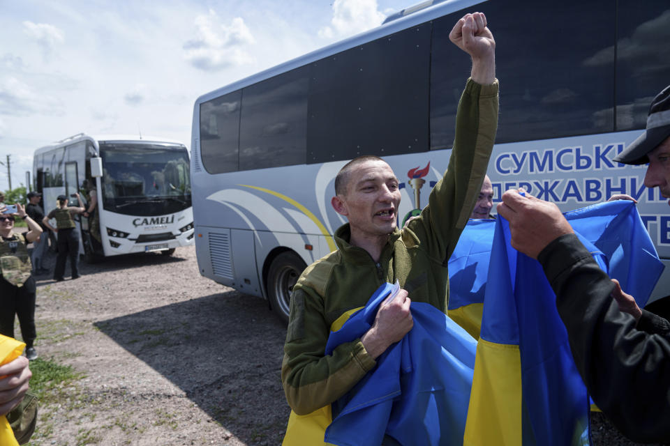A Ukrainian serviceman shouts "Glory to Ukraine" after returning from captivity during POWs exchange in Sumy region, Ukraine, Friday, May 31, 2024. Ukraine returned 75 prisoners, including four civilians, in the latest exchange of POWs with Russia. It's the fourth prisoner swap this year, and 52nd since Russia invaded Ukraine. In all, 3 210 Ukrainian servicemen and civilians were returned since the outbreak of the war. (AP Photo/Evgeniy Maloletka)