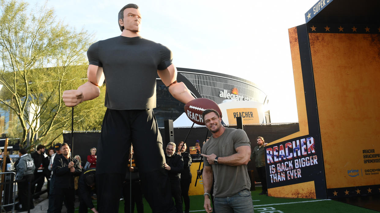  Alan Ritchson celebrates Prime Video's Season 2 of "Reacher" with a larger-than-life action figure during Thursday Night Football at Allegiant Stadium on December 14, 2023 in Las Vegas, Nevada. 