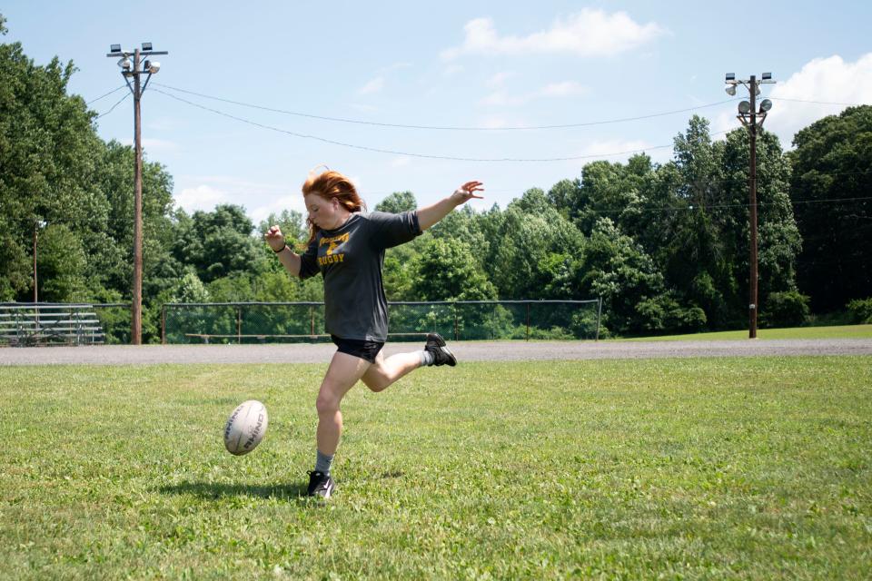 Doylestown Rugby player Maddie Doyle poses for a portrait drop kicking the ball on the Doylestown Rugby Club field in Doylestown on Thursday, July 21, 2022.