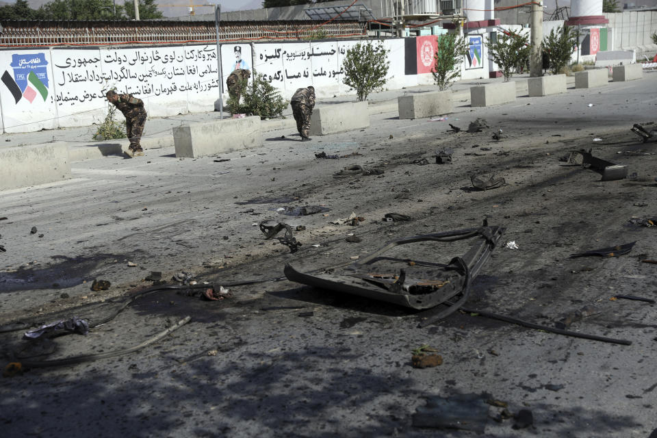 Afghan security personnel inspect the site of a bomb explosion in Kabul, Afghanistan, Thursday, June 3, 2021. Police say a bomb has ripped through a minivan in the western part of the Afghan capital Kabul, killing at least four people. No one took responsibility for the attack in the neighborhood, which is largely populated by the minority Hazara ethnic group who are mostly Shiite Muslims. (AP Photo/Rahmat Gul)