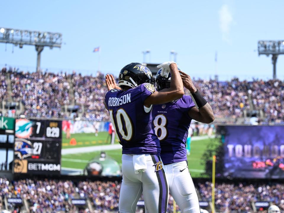 Lamar Jackson and Demarcus Robinson celebrate a touchdown against the Miami Dolphins.