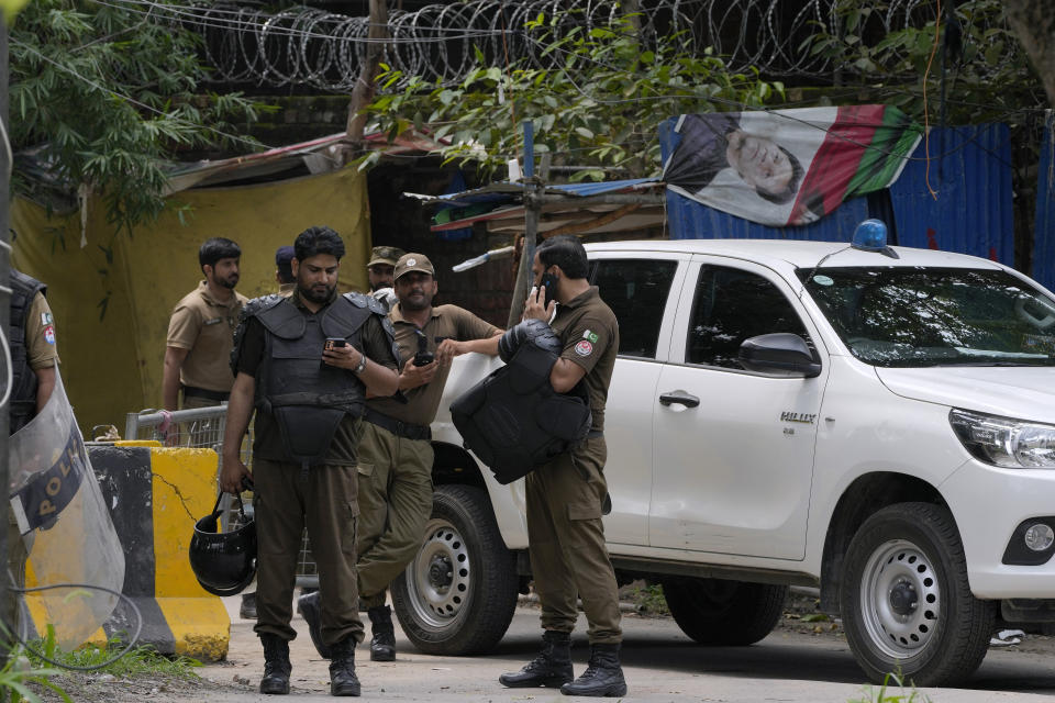 Agentes de policía se preparan para tomar posiciones en el exterior de la residencia del exprimer ministro Imran Khan, en Lahore, Pakistán, el 5 de agosto de 2023. (AP Foto/K.M. Chaudary)