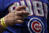 A fan holds a ball while waiting for autographs from players before a baseball game between the Arizona Diamondbacks and the Chicago Cubs in Chicago, Sunday, May 22, 2022. (AP Photo/Nam Y. Huh)