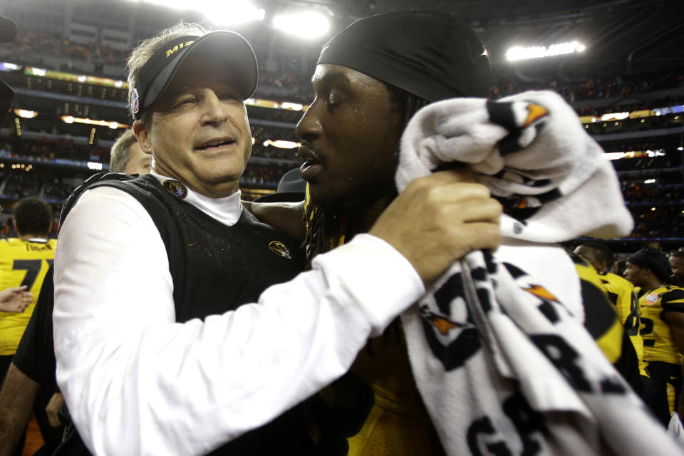 Missouri head coach Gary Pinkel and defensive lineman Markus Golden (33) embrace after beating Oklahoma State 41-31 at the Cotton Bowl NCAA college football game, Friday, Jan. 3, 2014, in Arlington, Texas. (AP Photo/Tim Sharp)