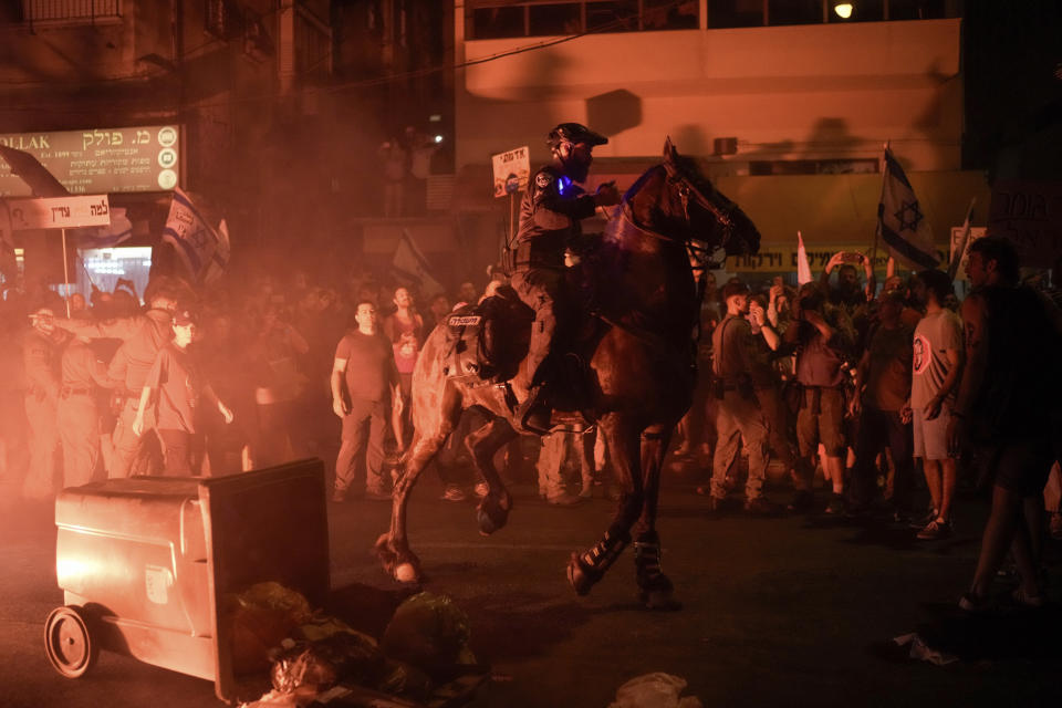 Israeli mounted police officers disperse demonstrators blocking a road during a protest against Israeli Prime Minister Benjamin Netanyahu's government and call for the release of hostages held in the Gaza Strip by the Hamas militant group, in Tel Aviv, Israel, Saturday, June 22, 2024. (AP Photo/Leo Correa)