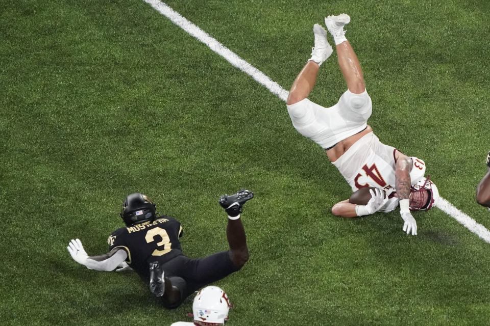 Elon tight end Cody Hardy (43) is upended by Wake Forest defensive back Malik Mustapha (3) during the first half of an NCAA college football game in Winston-Salem, N.C., Thursday, Aug. 31, 2023. (AP Photo/Chuck Burton)