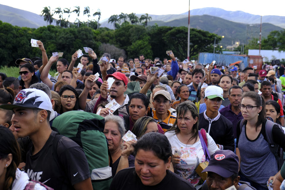 Venezuelans showing their IDs line up to cross the Simon Bolivar international bridge into Cucuta, Colombia, Saturday, June 8, 2019. Venezuela's President Nicolas Maduro ordered the partial re-opening of the border that has been closed since February when he stationed containers on the bridge to block an opposition plan to deliver humanitarian aid into the country. (AP Photo/Ferley Ospina)