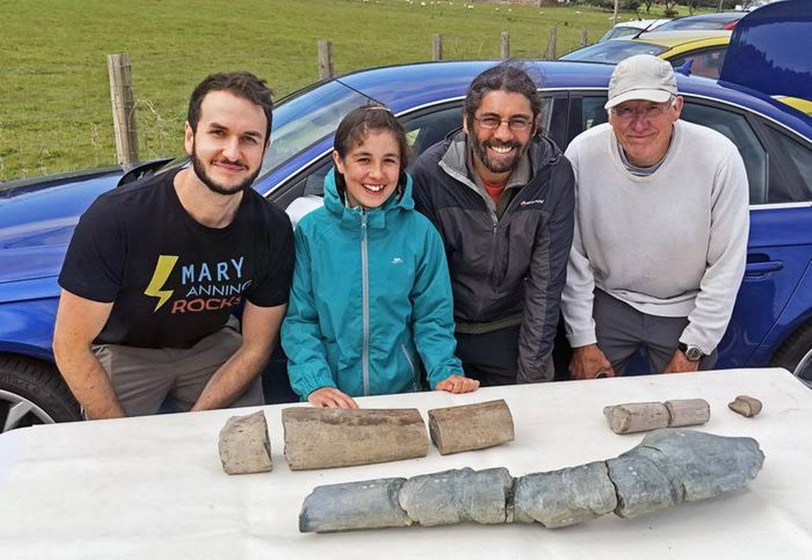 Ruby Reynolds, then 11 years old, was the first to spot a section of bone on the beach. She is pictured, from left, with Dean Lomax, her father Justin, and fossil hunter Paul de la Salle.