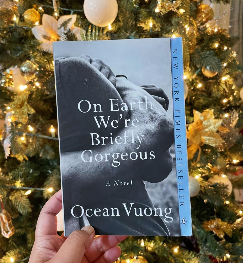 The author is holding her copy of Ocean Vuong's "On Earth We're Briefly Gorgeous"