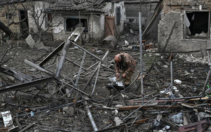 A police officer inspects remains of a Russian missile which hit a residential area, amid Russia's attack on Ukraine, in Zaporizhzhia, Ukraine April 9, 2023. - REUTERS/Stringer