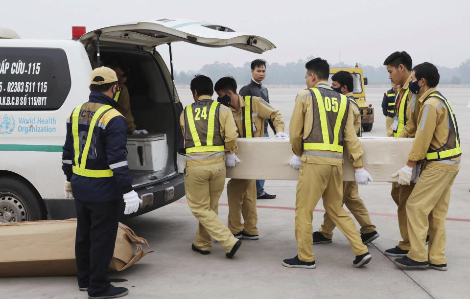 Airport workers load a coffin into the back of an ambulance at the Noi Bai airport in Hanoi, Vietnam, Saturday, Nov. 30, 2019. The last remains of the 39 Vietnamese who died while being smuggled in a truck to England last month have been repatriated to their home country. (Lam Khanh/VNA via AP)