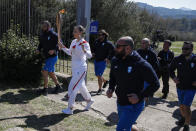 Greek shooting Olympic champion Anna Korakaki, the first torchbearer, holds the torch following the flame lighting ceremony at the closed Ancient Olympia site, birthplace of the ancient Olympics in southern Greece, Thursday, March 12, 2020, 2020. Greek Olympic officials are holding a pared-down flame-lighting ceremony for the Tokyo Games due to concerns over the spread of the coronavirus. Both Wednesday's dress rehearsal and Thursday's lighting ceremony are closed to the public, while organizers have slashed the number of officials from the International Olympic Committee and the Tokyo Organizing Committee, as well as journalists at the flame-lighting. (AP Photo/Thanassis Stavrakis)