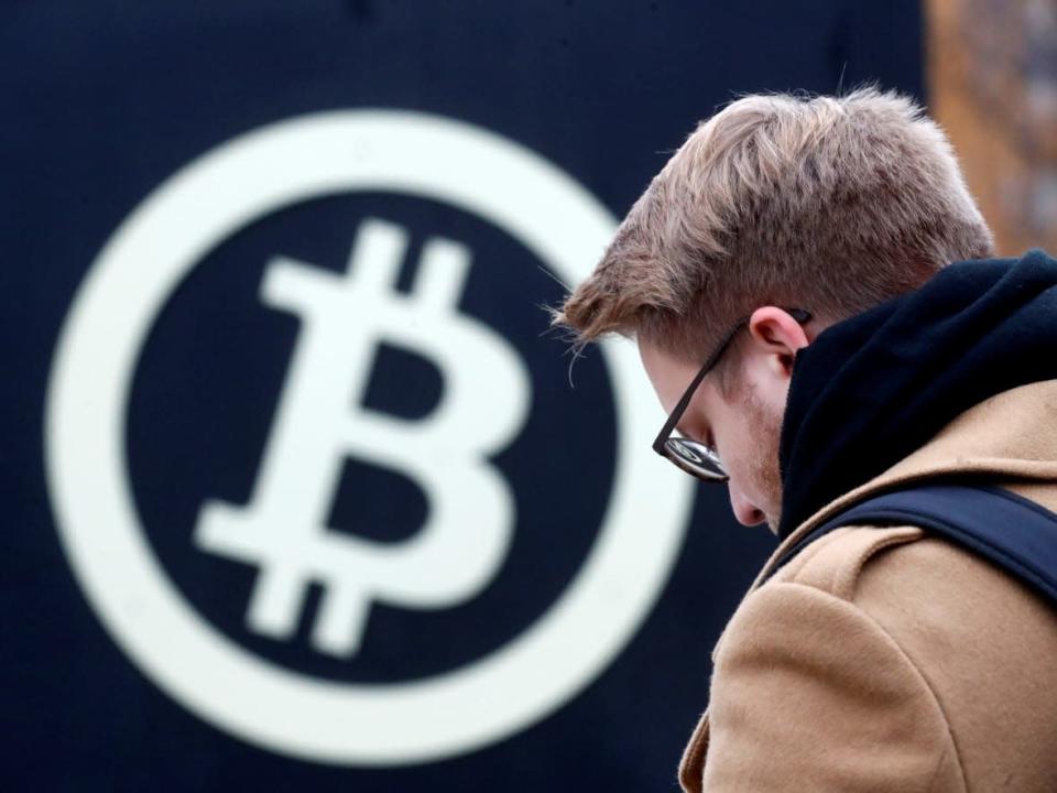 After peaking in November 2021, bitcoin has lost half of its value. A man stands next to the bitcoin sign in Riga, Latvia, Nov. 9, 2017. (Ints Kalnins/Reuters - image credit)