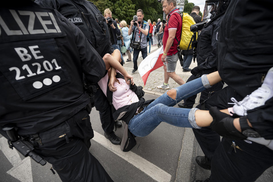Police arrest a demonstrator at an unannounced demonstration at the Victory Column, in Berlin, Sunday Aug. 1, 2021, during a protest against coronavirus restrictions. Hundreds have turned out in Berlin to protest the German government’s anti-coronavirus measures despite a ban on the gatherings, leading to arrests and clashes with police. (Fabian Sommer/dpa via AP)