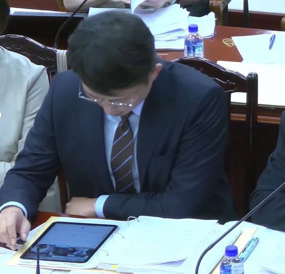 黃國昌被發現在憲法法庭看自己的直播留言。   圖：翻攝畫面