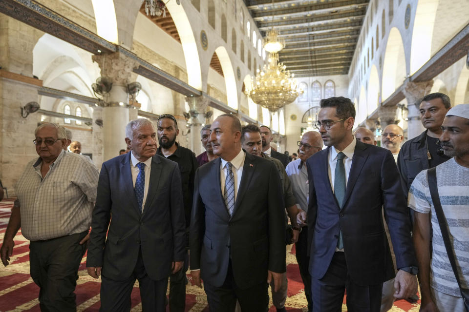 Turkish Foreign Minister Mevlut Cavusoglu, center, and Director of Jerusalem Waqf Department, Sheikh Azzam Al-Khatib, second left, and other dignitaries visit the Al Aqsa Mosque compound in Jerusalem's Old City, Wednesday, May 25, 2022. (AP Photo/ Mahmoud Illean)