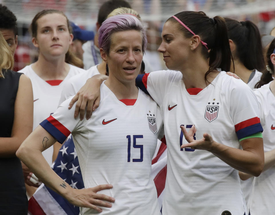 FILE - In this July 7, 2019, file photo, United States' Megan Rapinoe, left, talks to her teammate Alex Morgan, right, after winning the Women's World Cup final soccer match against Netherlands at the Stade de Lyon in Decines, outside Lyon, France. Players for the U.S. women’s national team may have been dealt a blow by a judge’s ruling in their gender discrimination case against U.S. Soccer, but the case is far from over. On Friday a federal judge threw out the players' unequal pay in a surprising loss for the defending World Cup champions. But the judge allowed aspects of their allegations of discriminatory working conditions to go to trial. (AP Photo/Alessandra Tarantino, File)