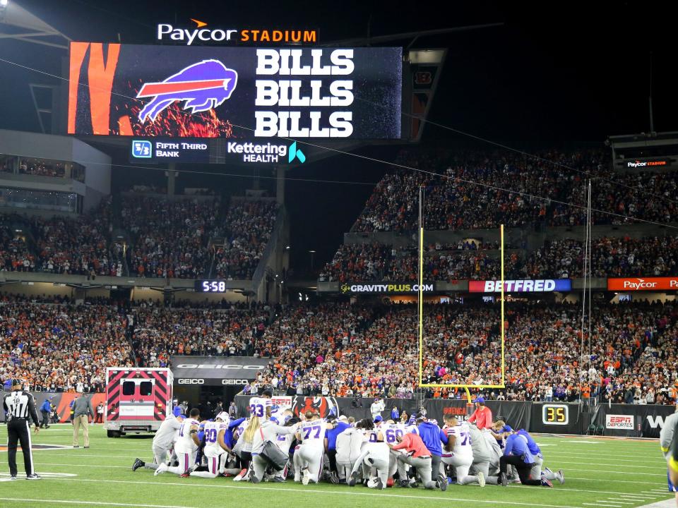 Bills players pray as Damar Hamlin is escorted to a nearby hopsital.